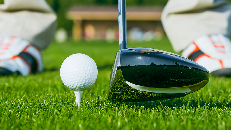 Golfer warming up before a round to prevent early-season golf injuries